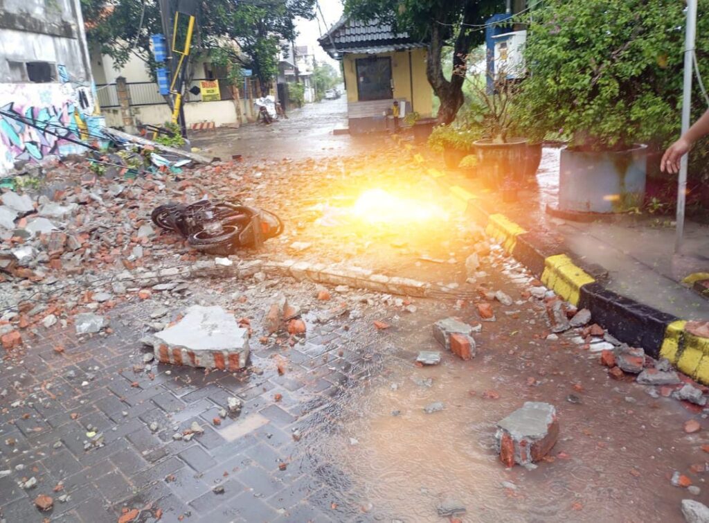 Hujan Lebat Disertai Angin Kencang, Tembok Rumah Roboh Timpa Pengendara di Kebraon Indah Mas